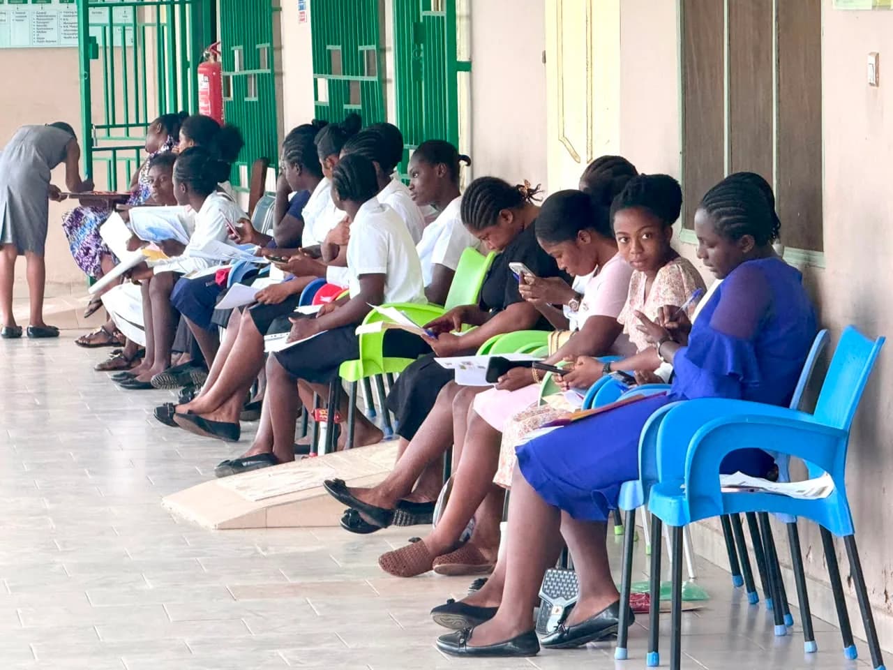 Applicants reviewing their forms while waiting for interview